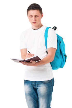Portrait of a caucasian guy carrying some books and a backpack, isolated on white background. Smart  student of college or university writes in a notebook lecture.の写真素材