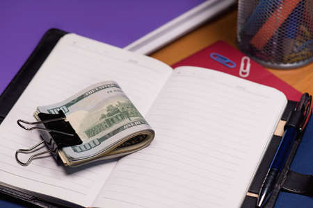 Empty notepad with US dollar banknotes and pen on tableの写真素材
