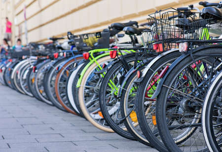 Group of bicycles in the row on sidewalk. Selective focus. Parking for bikes in big European city. Close up of wheel.の写真素材