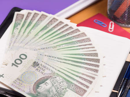 Notepad with Polish money banknotes on tableの写真素材