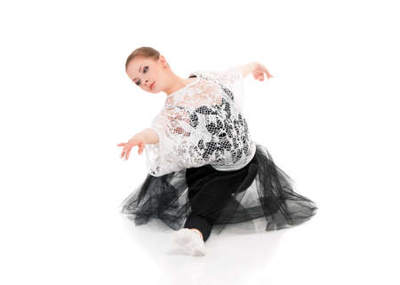 Young beautiful dancer posing on isolated white studio background. Pretty woman - modern style dancer or ballerina in ballet pose.の写真素材