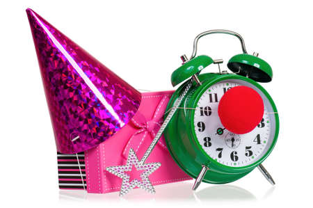 Alarm clock with clown nose. Birthday cap, gift box and magic wand. Time for the holiday's concept with clock and present, isolated on white background.の写真素材