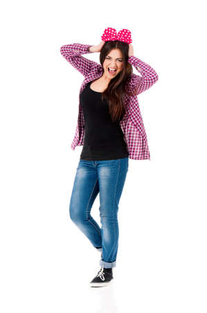Cheerful teen girl with big red bow, isolated on white background. Full length portrait of beautiful crazy smiling brunette young woman screaming with mouth wide open.の写真素材