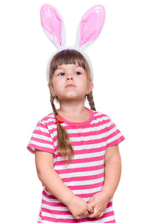 Happy little girl with pink rabbit ears. Portrait of cute caucasian baby wearing bunny ears. Funny preschool child, isolated on white background. Healthy carefree kid - Easter holidays concepts.の写真素材