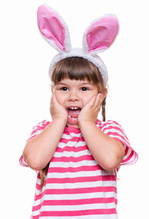 Happy little girl with pink rabbit ears. Portrait of cute caucasian baby wearing bunny ears. Funny preschool child, isolated on white background. Healthy carefree kid - Easter holidays concepts.の写真素材