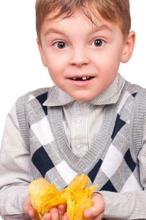 Portrait of cheerful little boy with packet of potato chips. Close-up of child eating fast food, isolated on white background.の写真素材
