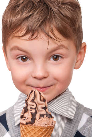 Portrait of cheerful little boy with ice cream cone. Close-up of child eating ice-cream with chocolate, isolated on white background.の写真素材