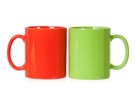 Two mugs - green and red - for coffee or tea, isolated on white backgroundの写真素材