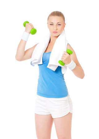 Young woman doing fitness exercise with dumbbells and towel, isolated on white background. Portrait of beautiful athlete girl in studio.の写真素材