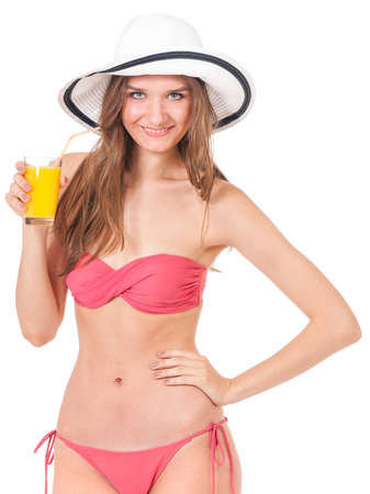Pretty girl posing in bikini, drink orange juice, isolated on white backgroundの写真素材