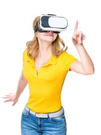 Woman wearing virtual reality goggles watching movies or playing video games, isolated on white background. Cheerful girl looking in VR glasses, pointing with finger.の写真素材