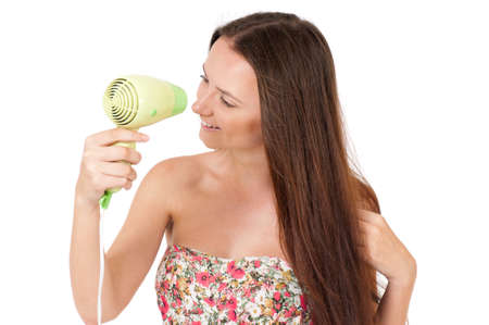 Attractive teenager girl holding hair dryer, isolated white backgroundの写真素材