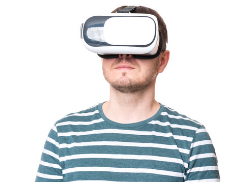 Man wearing virtual reality goggles watching movies or playing video games - closeup. Male looking...