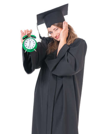 Young graduate girl student in mantle with alarm clock, isolated on white backgroundの写真素材