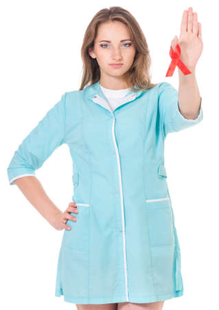 Female doctor holding a red ribbon as a symbol of AIDSの写真素材