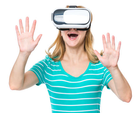 Amazed woman wearing virtual reality goggles watching movies or playing video games. Female getting experience using VR-headset glasses of virtual reality at home much gesticulating hands.の写真素材