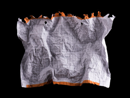Crumpled piece of white blank squared paper exercise book on black background.
