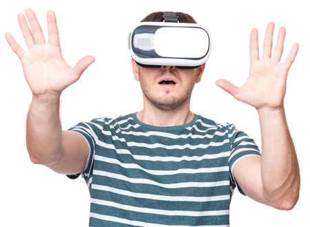 Amazed man wearing virtual reality goggles watching movies or playing video games, isolated on white background. Surprised male in VR glasses. People experiencing 3D technology.の写真素材