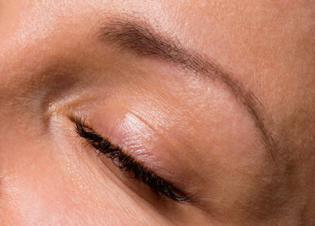 Close-up face of beautiful young woman with beautiful big eyelashes and eyebrows. Macro of human eye...