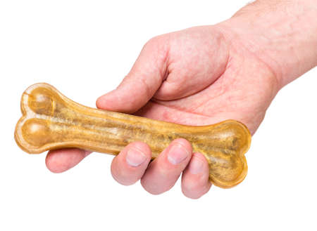 Male hand holding Dog chew bone food - pet accessories for eat, isolated on white background with copy spaceの写真素材