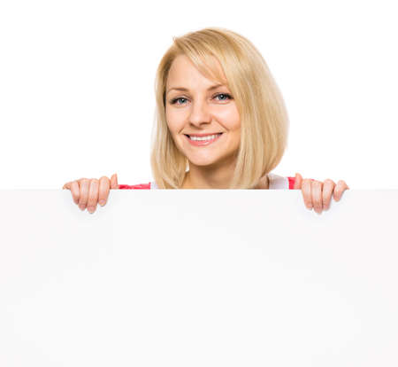 Portrait of happy smiling young woman, showing empty blank signboard with copyspace. Businesswoman holding big white banner, isolated on white background.の写真素材