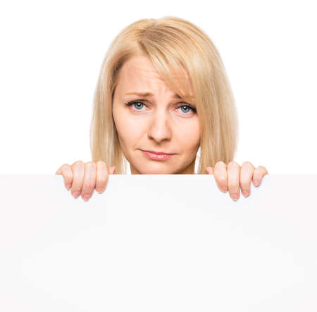 Portrait of sad young woman, showing empty blank signboard with copyspace. Businesswoman holding big white banner, isolated on white background.の写真素材