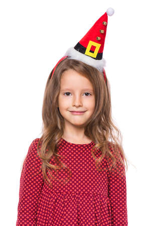 Portrait of smiling little girl with Santa Claus hat. Holiday Christmas concept - happy cute child isolated on white background.の写真素材