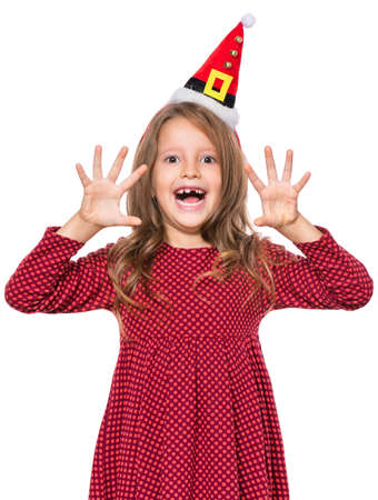 Portrait of smiling little girl with Santa Claus hat. Holiday Christmas concept - happy cute child isolated on white background.の写真素材
