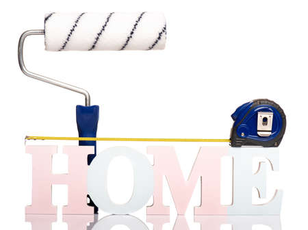 HOME word concept - Text Banner with Tape Measure tool and Paint Roller Brush, isolated on white background.の写真素材