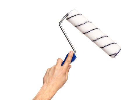 Close up view of Worker Man Hand with Paint Roller Brush. Male Hand with Tools. Human hand holding new Roller, isolated on white background.の写真素材