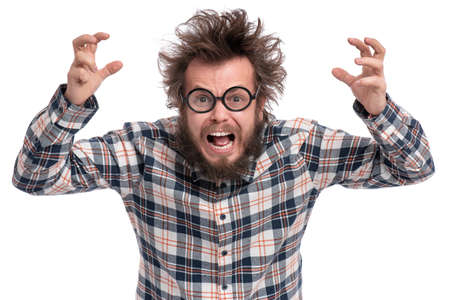 Crazy angry Man with funny Haircut in Eyeglasses. Bearded Enraged furious guy in plaid shirt screaming in anger, isolated on white background. Emotions and signs concept.の写真素材