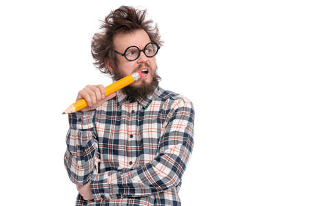 Crazy thoughtful bearded Man in plaid shirt with funny Haircut in eye Glasses holding Big Pencil - ponder and dreaming, isolated on white background.の写真素材