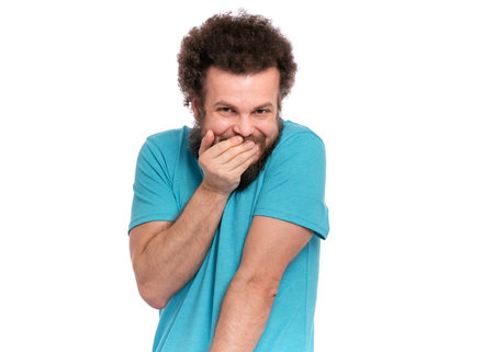 Crazy bearded modest and embarrassed Man with funny Curly Hair, isolated on white background. He is...