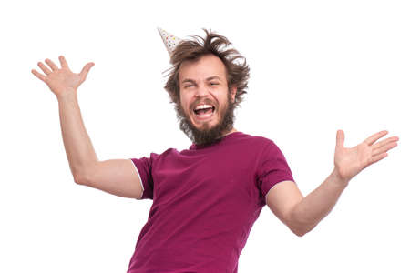 Crazy bearded Man with funny Haircut in birthday cap, isolated on white background. Happy guy screaming and keeping mouth open. Holidays, Emotions and Signs concept.の写真素材