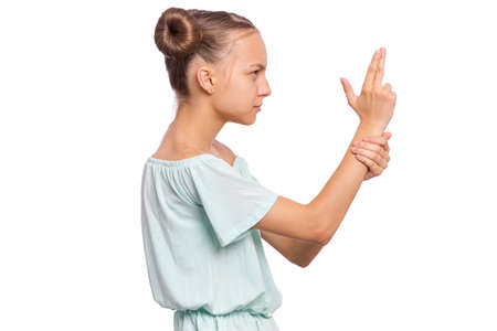 Portrait of funny teen girl doing gun gesture getting ready to shoot. Caucasian young teenager showing raised gun gesture isolated on white background. Child holding symbolic gun. Emotions and signs.の写真素材