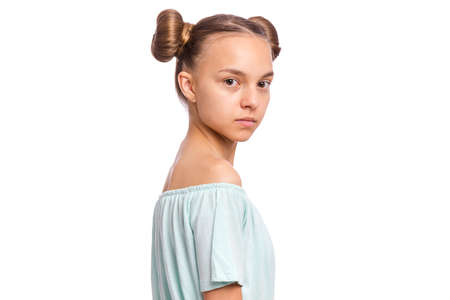 Portrait of happy teen girl with funny hairstyle, isolated on white background. Smiling child looking at camera. Beautiful young caucasian teenager.の写真素材