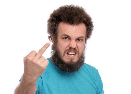 Crazy bearded Man with funny Curly Hair Screaming and showing the Middle Finger, isolated on white background. Portrait of Angry Man looking at camera in anger - studio shot.の写真素材
