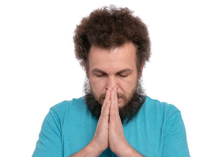 Portrait of caucasian crazy bearded Man with funny Curly Hair - saying prayers, isolated on white background. Religious image - Guy praying and praising God.の写真素材