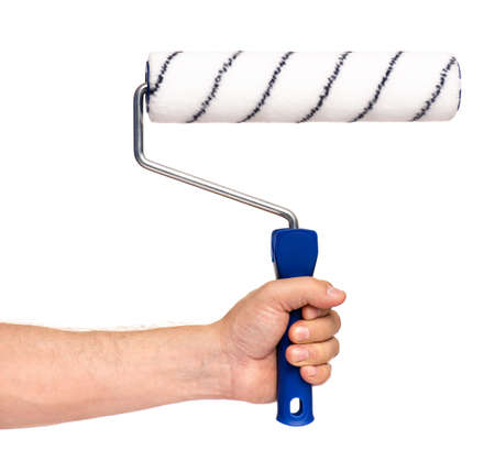 Close up view of Worker Man Hand with Paint Roller Brush. Male Hand with Tools. Human hand holding new Roller, isolated on white background.の写真素材