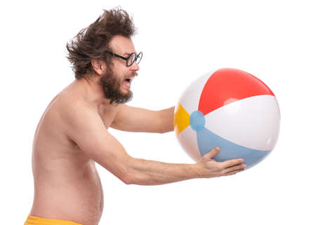 Crazy bearded Man with funny Haircut in eye Glasses, ready for fun at sunny beach. Happy and silly tourist, isolated on white background. Cheerful naked man holding Sea Ball.の写真素材