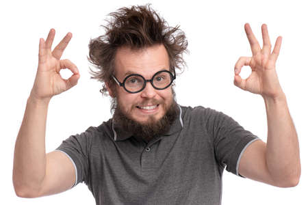 Crazy Bearded happy Man with funny Haircut in Eyeglasses making Ok gesture. Cheerful and silly guy, isolated on white background.の写真素材