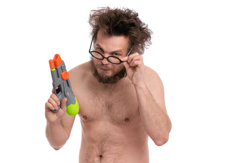 Crazy bearded Man with funny Haircut in eyeglasses, ready for fun at sunny beach. Happy and silly tourist, isolated on white background. Cheerful naked man holding Water Gun.の写真素材