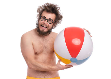 Crazy bearded Man with funny Haircut in eye Glasses, ready for fun at sunny beach. Happy and silly tourist, isolated on white background. Cheerful naked man holding Sea Ball.の写真素材