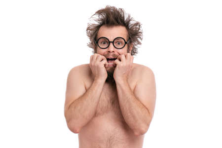 Crazy bearded Scared Man with funny Haircut in Eyeglasses, bites his nails and looks worried. Naked guy afraid and shocked, isolated on white background.の写真素材