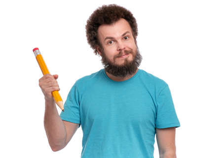 Crazy bearded Man with funny Curly Hair holding Big Pencil, isolated on white background. Happy Guy looking at camera.の写真素材