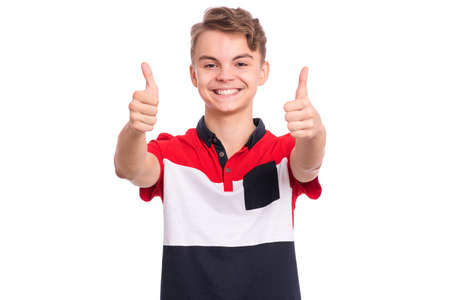 Portrait of teen boy making thumbs up gesture, isolated on white background. Handsome caucasian young teenager smiling and showing success sign. Happy cute child looking at camera.の写真素材