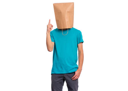 Portrait of teen boy with paper bag over head pointing hands away at copyspace - has an idea, isolated on white background. Child pointing finger up at something.の写真素材