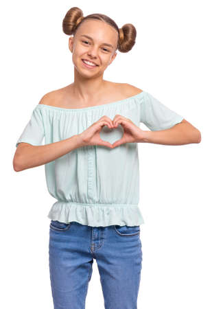Portrait of smiling teen girl making Heart Gesture with fingers. Happy child with hands in heart shape. Young student showing signs of Love, isolated on white background. Valentines Day concept.の写真素材
