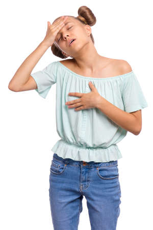 Portrait of tired teen girl touching head suffering headache. Unhappy beautiful caucasian young teenager suffering from headache. Sad teenager isolated on white background.の写真素材