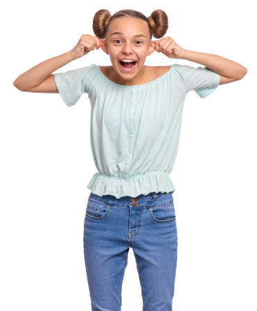 Silly teen girl making grimace - funny monkey face. Child with big ears, isolated on white background. Emotional portrait of teenager looking at camera. Attractive boy stretching ears imitating monkeyの写真素材